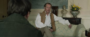 Movie still from “My Cousin Rachel” (2017), directed by Roger Michell – A man sitting on top of a couch next to another man; Medium shot, Over the shoulder angle