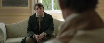 Movie still from “My Cousin Rachel” (2017), directed by Roger Michell – A man sitting in front of another man in front of a window; Medium shot, Over the shoulder angle