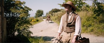 Movie still from “My Cousin Rachel” (2017), directed by Roger Michell – A man wearing a hat and holding a cane; Medium shot, Over the shoulder angle