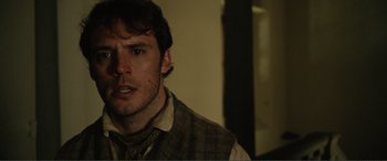 Movie still from “My Cousin Rachel” (2017), directed by Roger Michell – A person wearing a plaid vest; Close Up shot, Over the shoulder angle