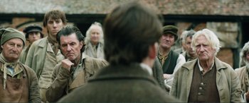Movie still from “My Cousin Rachel” (2017), directed by Roger Michell – A group of men standing next to each other; Medium shot, Over the shoulder angle