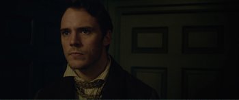 Movie still from “My Cousin Rachel” (2017), directed by Roger Michell – A person wearing a suit and tie; Close Up shot, Over the shoulder angle