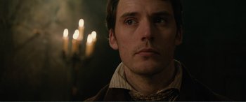 Movie still from “My Cousin Rachel” (2017), directed by Roger Michell – A man's face in front of candles; Close Up shot, Over the shoulder angle