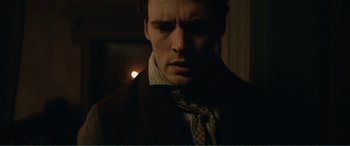 Movie still from “My Cousin Rachel” (2017), directed by Roger Michell – A person wearing a suit and tie; Close Up shot, Over the shoulder angle
