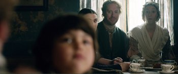 Movie still from “My Cousin Rachel” (2017), directed by Roger Michell – A man and a woman sitting next to a child; Medium shot, Over the shoulder angle