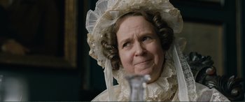 Movie still from “My Cousin Rachel” (2017), directed by Roger Michell – An older woman wearing a white dress and a white hat; Close Up shot, Over the shoulder angle