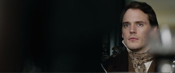 Movie still from “My Cousin Rachel” (2017), directed by Roger Michell – A man in a black jacket is sitting at a table; Close Up shot, Over the shoulder angle