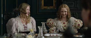 Movie still from “My Cousin Rachel” (2017), directed by Roger Michell – Two women sitting at a table with a wine glass; Medium shot, Over the shoulder angle