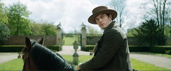Movie still from “My Cousin Rachel” (2017), directed by Roger Michell – A man wearing a hat and riding on a horse; Medium shot, Over the shoulder angle