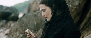 Movie still from “My Cousin Rachel” (2017), directed by Roger Michell – A woman in a black veil looking at a cell phone; Close Up shot, High angle