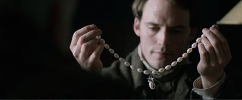 Movie still from “My Cousin Rachel” (2017), directed by Roger Michell – A man holding a necklace of pearls in his hand; Extreme Close Up shot, Over the shoulder angle