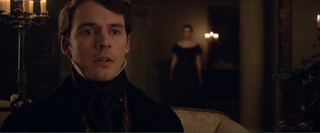 Movie still from “My Cousin Rachel” (2017), directed by Roger Michell – A man and a woman standing in front of a couch; Close Up shot, Over the shoulder angle