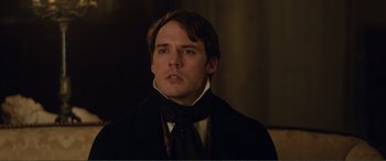 Movie still from “My Cousin Rachel” (2017), directed by Roger Michell – A person wearing a suit and tie; Close Up shot, Over the shoulder angle