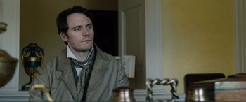 Movie still from “My Cousin Rachel” (2017), directed by Roger Michell – A man wearing a jacket and a scarf looking into a mirror; Close Up shot, Over the shoulder angle