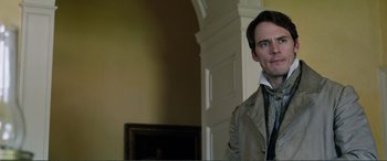 Movie still from “My Cousin Rachel” (2017), directed by Roger Michell – A man standing in front of a fireplace in a living room; Close Up shot, Over the shoulder angle