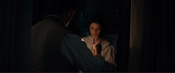 Movie still from “My Cousin Rachel” (2017), directed by Roger Michell – A man and a woman are holding a candle; Medium shot, Over the shoulder angle