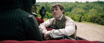 Movie still from “My Cousin Rachel” (2017), directed by Roger Michell – A man sitting in a car on the side of the road; Medium shot, Over the shoulder angle