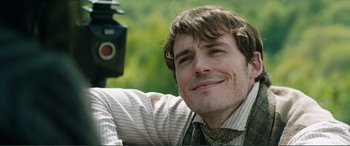 Movie still from “My Cousin Rachel” (2017), directed by Roger Michell – A young man is smiling for the camera; Close Up shot, Over the shoulder angle