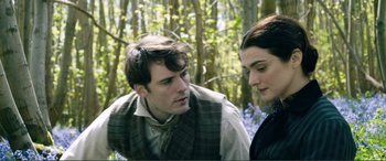 Movie still from “My Cousin Rachel” (2017), directed by Roger Michell – A man and a woman standing next to each other in the woods; Close Up shot, Over the shoulder angle