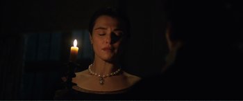 Movie still from “My Cousin Rachel” (2017), directed by Roger Michell – A woman with a necklace and a candle in the dark; Close Up shot, Over the shoulder angle