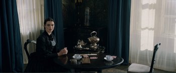 Movie still from “My Cousin Rachel” (2017), directed by Roger Michell – A woman sitting at a table with a tea pot and tea cups; Medium shot, High angle