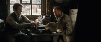 Movie still from “My Cousin Rachel” (2017), directed by Roger Michell – A man sitting at a table in front of papers; Medium shot, Over the shoulder angle