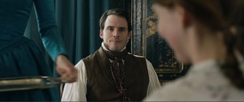 Movie still from “My Cousin Rachel” (2017), directed by Roger Michell – A man wearing a vest and a neck tie in front of a woman; Close Up shot, Over the shoulder angle