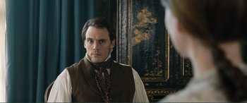 Movie still from “My Cousin Rachel” (2017), directed by Roger Michell – A man in a vest and tie looking into a mirror; Close Up shot, Over the shoulder angle