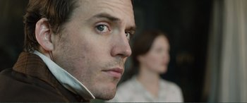 Movie still from “My Cousin Rachel” (2017), directed by Roger Michell – A man's face with a woman in the background; Close Up shot, Over the shoulder angle