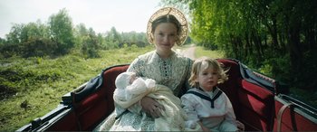 Movie still from “My Cousin Rachel” (2017), directed by Roger Michell – A woman and a child are sitting in the back of a car; Medium shot, High angle