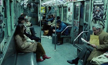 Movie still from “My Dinner with Andre” (1981), directed by Louis Malle – A group of people sitting on a subway train; Wide shot, High angle