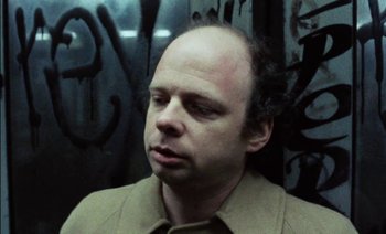 Movie still from “My Dinner with Andre” (1981), directed by Louis Malle – A man in a tan jacket looking to his left; Close Up shot, Low angle