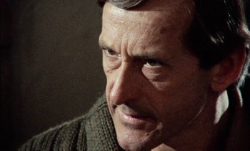 Movie still from “My Dinner with Andre” (1981), directed by Louis Malle – A man's face with a woolen sweater on; Close Up shot, Over the shoulder angle