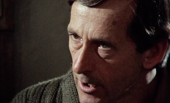 Movie still from “My Dinner with Andre” (1981), directed by Louis Malle – A person wearing a sweater; Close Up shot, Over the shoulder angle