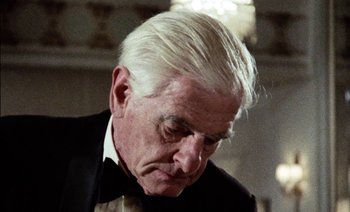 Movie still from “My Dinner with Andre” (1981), directed by Louis Malle – An older man with white hair wearing a tuxedo; Close Up shot, Low angle