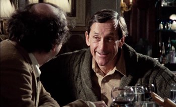 Movie still from “My Dinner with Andre” (1981), directed by Louis Malle – A man sitting at a table with another man in front of him; Close Up shot, Over the shoulder angle