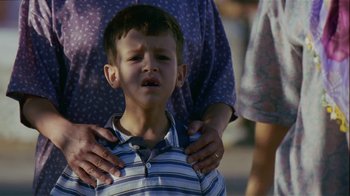 Movie still from “My Father and My Son” (2005), directed by Çagan Irmak – A child being held by a person with his hands on his chest; Close Up shot, High angle