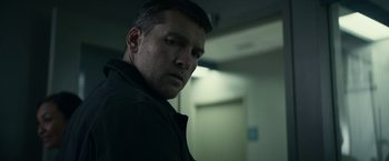 Movie still from “Fractured” (2019), directed by Brad Anderson – A person wearing a black shirt; Close Up shot, Over the shoulder angle