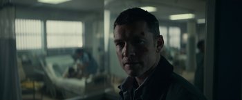 Movie still from “Fractured” (2019), directed by Brad Anderson – A person in a dark room; Close Up shot, Over the shoulder angle