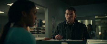 Movie still from “Fractured” (2019), directed by Brad Anderson – A man sitting at a table in front of another man; Medium shot, Over the shoulder angle