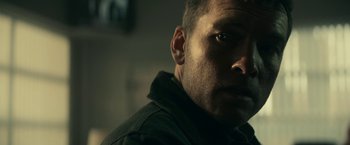 Movie still from “Fractured” (2019), directed by Brad Anderson – A man's face in a dark room; Close Up shot, Low angle