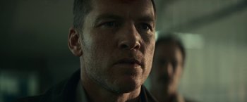 Movie still from “Fractured” (2019), directed by Brad Anderson – A man's face in a dark room; Close Up shot, Low angle