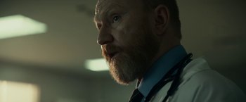 Movie still from “Fractured” (2019), directed by Brad Anderson – A person with a stethoscope; Close Up shot, Low angle