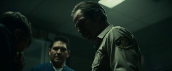 Movie still from “Fractured” (2019), directed by Brad Anderson – A man in a uniform standing next to another man in a suit; Medium shot, Low angle