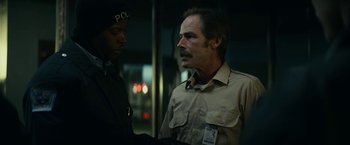 Movie still from “Fractured” (2019), directed by Brad Anderson – A man in a police uniform talking to another man in a uniform; Close Up shot, Over the shoulder angle