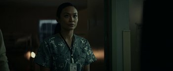 Movie still from “Fractured” (2019), directed by Brad Anderson – A woman in a hospital gown standing in front of a window; Medium shot, Low angle