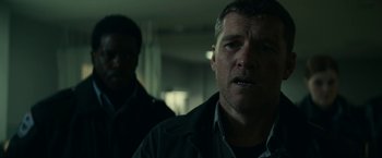 Movie still from “Fractured” (2019), directed by Brad Anderson – A man in a black jacket and a man in a white shirt; Close Up shot, Over the shoulder angle