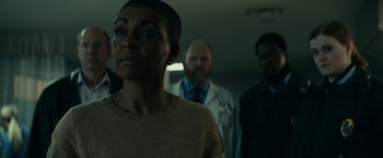 Movie still from “Fractured” (2019), directed by Brad Anderson – A group of people standing in a room; Close Up shot, Low angle