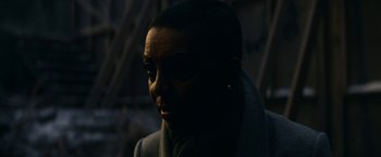 Movie still from “Fractured” (2019), directed by Brad Anderson – A man with a beard is standing in the dark; Close Up shot, Over the shoulder angle