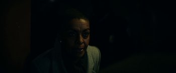 Movie still from “Fractured” (2019), directed by Brad Anderson – A woman is looking at the camera in the dark; Close Up shot, Over the shoulder angle